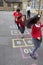 Group Of Children Playing Hopscotch In School Playground