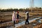 Group of children playing with thin ice puddles formed on the frozen soil in winter. Kids having fun in winter