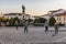 Group of children plays with a ball in the Plaza de Hernan Cortes with the statue of the Conquistador in the background