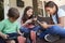 Group Of Children Sit On Porch Playing With Digital Devices