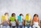 Group of children sitting and reading in front of grey background