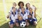 Group Of Children In Soccer Team Celebrating With Trophy