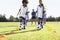 Group Of Children In Soccer Team Having Training With Coach