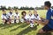 Group Of Children In Soccer Team Having Training With Coach