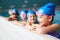 Group Of Children In Water At Edge Of Pool Waiting For Swimming Lesson