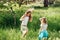 Group Of Children Wearing Bunny Ears Running To Pick Up colorful Egg On Easter Egg Hunt In Garden. Easter tradition