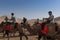 Group of Chinese tourists riding camels at the Echoing Sand Mountain near the city of Dunhuang, in the Gansu Province, China.