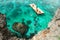 Group chinese tourists snorkeling in turquoise sea about rocky coast of the Crystal Cove island near Boracay