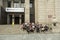 Group of Chinese tourists taking rest at the stairs of Bank of China entrance