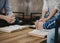 group of christian sitting around wooden table with open blurred bible page and praying to God together