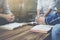 group of christian sitting around wooden table with open blurred bible on weedrn backgrund