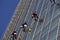 Group of cleaner hanging, washing and cleaning windows on high rise building - High building and Risk working