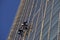 Group of cleaner hanging, washing and cleaning windows on high rise building - High building and Risk working
