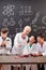 Group of clever students of secondary school watching chemical experiment