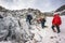 Group of climbers ascent to the mountain on a complex slope is composed of rock and snow