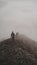 Group of climbers going down mountain ridge surrounded by fog.  27 March 2022, Gowa, Indonesia.