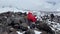 A group of climbers with large backpacks walk uphill over the rocks.