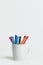 A group of color markers in a white cup