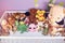 Group of colorful fluffy stuffed animal toys close up in a white wooden baby crib