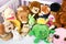 Group of colorful fluffy stuffed animal toys close up in a white wooden baby crib