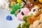 Group of colorful fluffy stuffed animal toys closeup with hanging red small baby shoe
