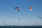 The group of colorful kitesurfing flying on the blue sky at Brighton le sands beach on a windy day.