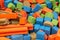 A group of coloured foam blocks in various shapes from cubes, rectangles, cylinders and more creating a colorful background for