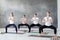 Group of concentrated yoga students doing rudrasana or goddess pose