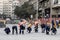 Group of construction and city sanitation workers using caulking guns and tiny paintbrushes trying to repair the street pavement