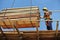 Group of construction workers lifting bundle of timber using mobile crane