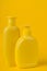 Group Cosmetic Bottles Isolated on Yellow Background.