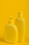 Group Cosmetic Bottles on Yellow Background.