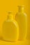 Group Cosmetic Bottles on Yellow Background.