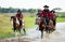 Group of cowboy and cowgirl ride horse through water in reservoir with day light