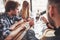 Group of creative multietnic friends sitting at wooden table. People having fun while playing board game