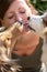 A group of cute funny dogs are licking the face of a beautiful young woman