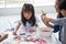 group of Cute little girl student painting  together with nursery teacher in classroom school . Happy children in a kindergarten