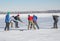 Group of different ages ordinary people playing hockey on a frozen river Dnipro in Ukraine
