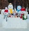 Group of different size dressed snowmen outdoors in winter