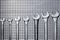 Group of different size wrenches a metallic grid with copy space for your text