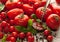 Group of different tomatoes among basil leaves and pepper