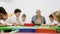 Group of diligent schoolkids drawing with cheerful female teacher at classroom