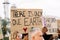 Group of diverse activist people protesting against climate change outdoors.