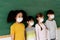 Group of diverse elementary students in classroom. Primary school pupils standing in a row wearing a face mask with