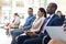 Group of diverse executives sat in conference room, smiling to camera