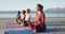 Group of diverse female friends meditating at the beach