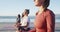 Group of diverse female friends meditating at the beach