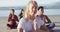 Group of diverse female friends meditating at the beach