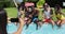 Group of diverse friends posing for a picture while sitting by the pool