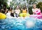 Group of diverse friends splashing water at the swimming pool